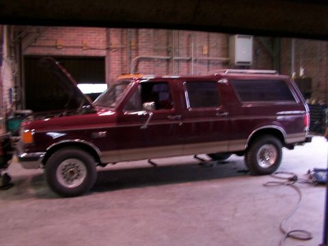 1988 Ford C-350 (Centurion Conversions) - This extended SUV is parked indoors with its hood up, possibly undergoing maintenance.