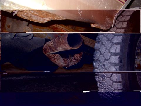 1988 Ford C-350 (Centurion Conversions) - This image shows a rusty exhaust pipe and a tire, not a 1988 Ford C-350 (Centurion Conversions).