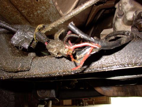 1988 Ford C-350 (Centurion Conversions) - Close-up view of frayed electrical wiring beneath a vehicle, likely related to the neutral safety switch.