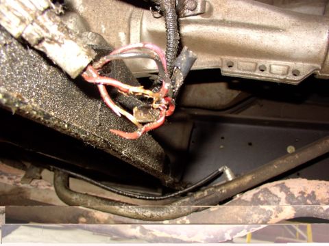 1988 Ford C-350 (Centurion Conversions) - Damaged wiring harness near the transmission, likely causing electrical issues.