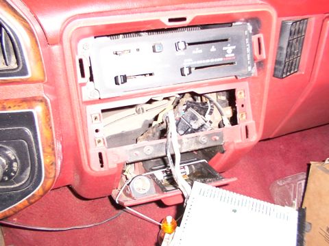 1988 Ford C-350 (Centurion Conversions) - The dashboard of a vehicle with the radio assembly removed, exposing wiring and internal components.