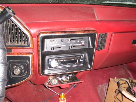 1988 Ford C-350 (Centurion Conversions) - The interior dashboard features an aftermarket radio and red carpeting. The vehicle's year and model are not definitively identifiable from…