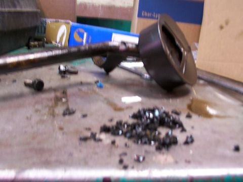 1988 Ford C-350 (Centurion Conversions) - Oil pan and metal debris on a workbench, likely from an engine repair.
