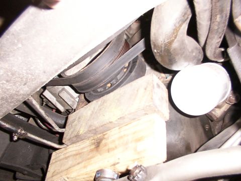 1988 Ford C-350 (Centurion Conversions) - Close-up view of the engine's belt and pulley system, with an oil filter also in frame.