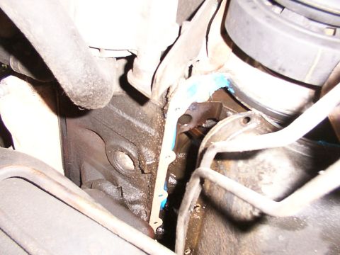 1988 Ford C-350 (Centurion Conversions) - Close-up of engine block with gasket and sealant, likely related to a rear main seal repair.