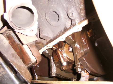 1988 Ford C-350 (Centurion Conversions) - Close-up view of an engine's crankshaft and connecting rod assembly, with visible oil and a gasket.