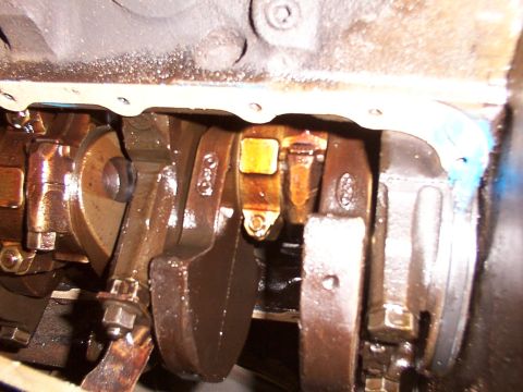 1988 Ford C-350 (Centurion Conversions) - Engine crankshaft and connecting rods, likely from a Ford vehicle, showing wear and oil.
