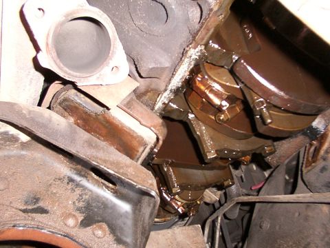1988 Ford C-350 (Centurion Conversions) - Close-up view of the internal engine components, showing the crankshaft and connecting rods covered in oil.