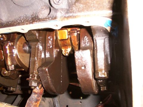 1988 Ford C-350 (Centurion Conversions) - Close-up view of engine crankshaft and connecting rods, showing oil accumulation.