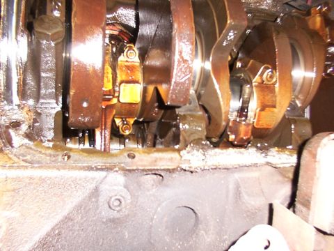 1988 Ford C-350 (Centurion Conversions) - This image shows the internal components of an engine, specifically the crankshaft and connecting rods, covered in oil.