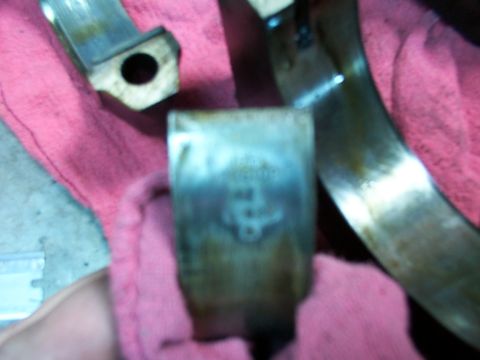 1988 Ford C-350 (Centurion Conversions) - Close-up of a worn engine bearing, showing signs of damage and discoloration.