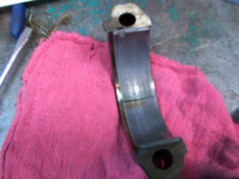 1988 Ford C-350 (Centurion Conversions) - Close-up of a worn engine bearing resting on a pink cloth, with a tool visible in the background.