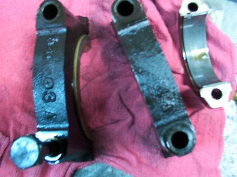 1988 Ford C-350 (Centurion Conversions) - Engine bearing caps, possibly for a Ford C-350, are laid out on a red cloth.