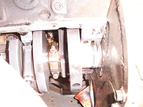 1988 Ford C-350 (Centurion Conversions) - Close-up view of the engine's crankshaft and connecting rod bearings, likely related to a rear main seal issue.