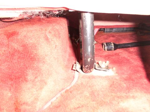 1988 Ford C-350 (Centurion Conversions) - Close-up of a seat mounting bracket and bolt in a vehicle's interior.