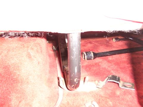 1988 Ford C-350 (Centurion Conversions) - Close-up view of a rear seat mounting bracket against red carpet.