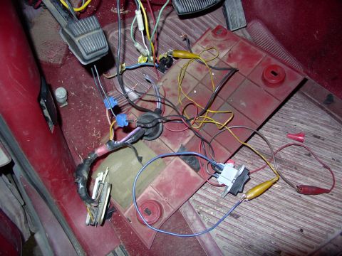 1988 Ford C-350 (Centurion Conversions) - Close-up of a vehicle's interior wiring harness and pedals, with a red floor mat visible.