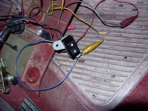1988 Ford C-350 (Centurion Conversions) - Close-up of a rear window wiring switch with alligator clips attached for testing.