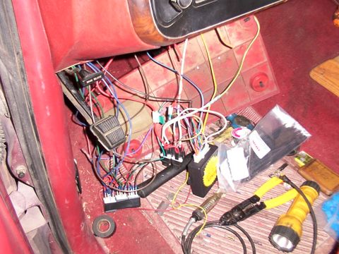1988 Ford C-350 (Centurion Conversions) - Close-up of complex wiring and remote start components installed in a vehicle's interior, alongside various tools.