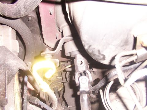 1988 Ford C-350 (Centurion Conversions) - Close-up view of a vehicle's steering column universal joint, showing mechanical linkages and electrical wiring.