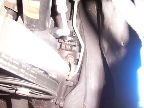 1988 Ford C-350 (Centurion Conversions) - Close-up view of the steering sector and a belt on a vehicle's engine.