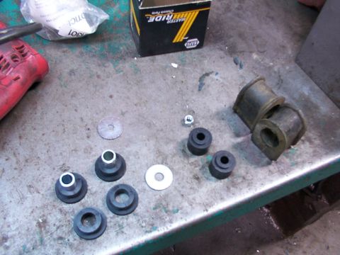 1988 Ford C-350 (Centurion Conversions) - Various suspension bushings and hardware are displayed on a metal surface, possibly for replacement.