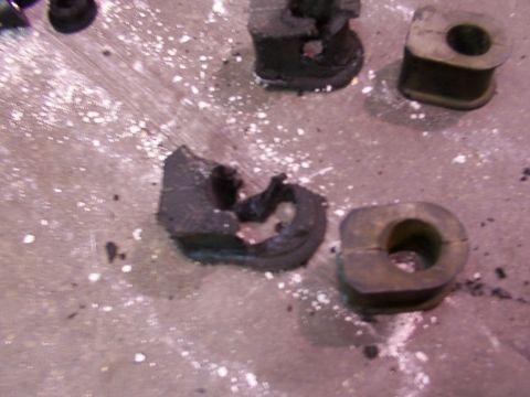 1988 Ford C-350 (Centurion Conversions) - Damaged rubber bushings, likely from a vehicle's suspension system, lie on a concrete floor.