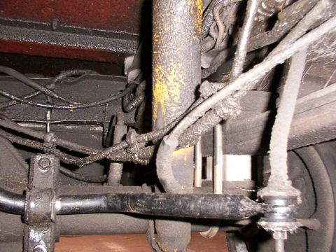 1988 Ford C-350 (Centurion Conversions) - Greasy suspension components, likely a sway bar link and shock absorber, are visible in this close-up.