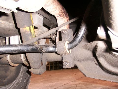 1988 Ford C-350 (Centurion Conversions) - Undercarriage view of a vehicle's rear sway bar and associated suspension parts, likely needing replacement.