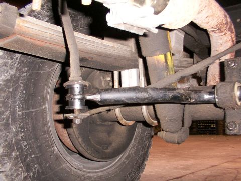 1988 Ford C-350 (Centurion Conversions) - Close-up view of the rear suspension system, showing a sway bar link and other components.
