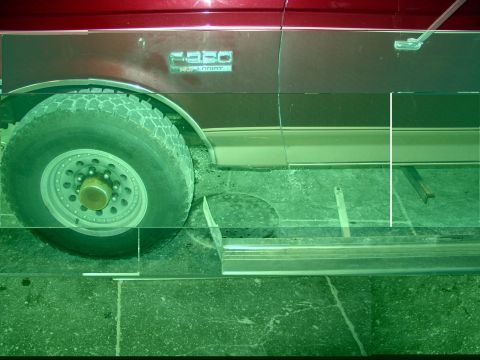 1988 Ford C-350 (Centurion Conversions) - Close-up of the side of a red Ford F-350 truck, showing the wheel, running board, and badging.