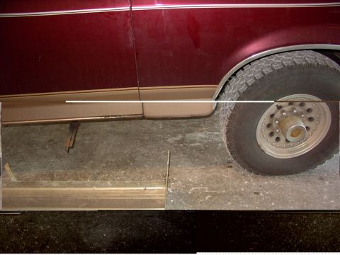1988 Ford C-350 (Centurion Conversions) - Close-up of a maroon vehicle's side, showing a tan stripe, a large tire, and a metal running board.