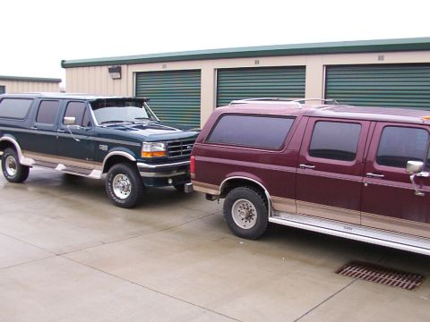 1988 Ford C-350 (Centurion Conversions) - Two Ford Bronco Centurions are parked outside storage units.