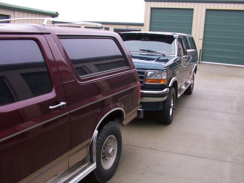 1988 Ford C-350 (Centurion Conversions) - Two SUVs are parked in front of storage units. The front vehicle appears to be a 1992 Ford F-Series SUV.