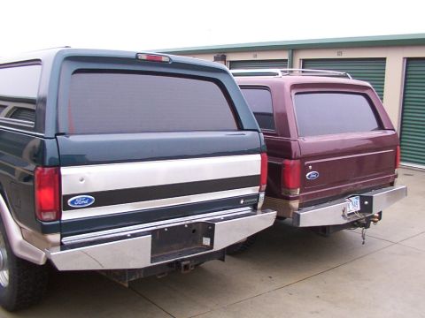 1988 Ford C-350 (Centurion Conversions) - Two Ford SUVs, likely Broncos or similar, with camper shells are parked side-by-side.