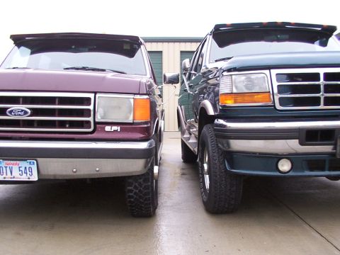 1988 Ford C-350 (Centurion Conversions) - Two Ford vans are parked next to each other, showing their front ends.