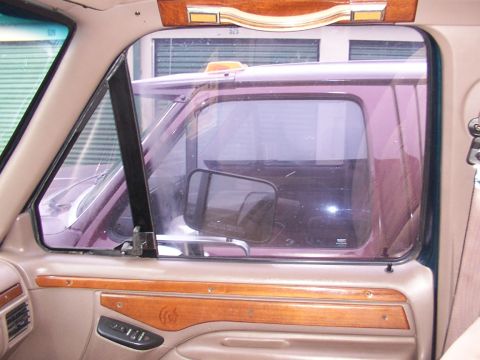 1988 Ford C-350 (Centurion Conversions) - Interior view of a truck cab, with another truck visible through the window.