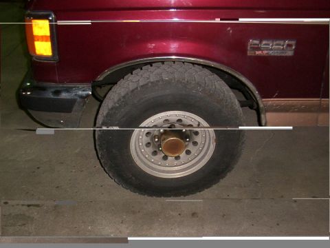 1988 Ford C-350 (Centurion Conversions) - Rear wheel and fender of a red 1988 Ford F-250 truck, identified by its side badge.