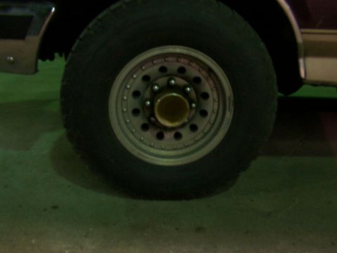 1988 Ford C-350 (Centurion Conversions) - A close-up view of a truck's wheel and tire, with a portion of the vehicle's body visible.