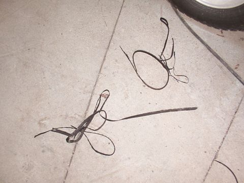 1988 Ford C-350 (Centurion Conversions) - Several pieces of rubber trim are scattered on a concrete floor, with a tire visible in the upper right corner.