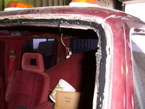 1988 Ford C-350 (Centurion Conversions) - Windshield seal replacement in progress on a 1988 Ford C-350 (Centurion Conversions). Interior shows red seats and roof-mounted emergency l…