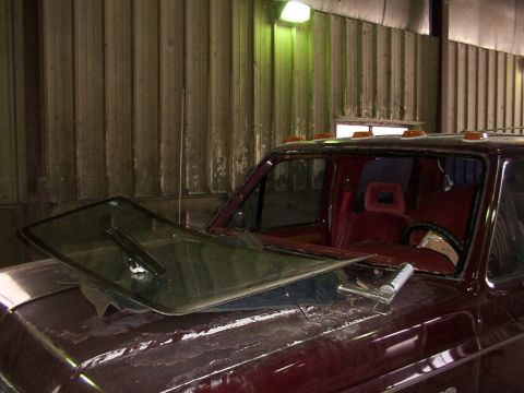 1988 Ford C-350 (Centurion Conversions) - The windshield of a maroon 1988 Ford C-350 (Centurion Conversions) truck has been removed and rests on the hood.