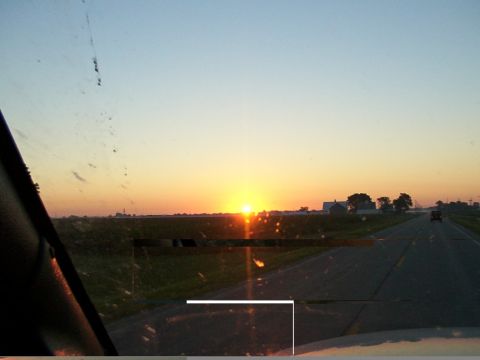 1988 Ford C-350 (Centurion Conversions) - Driving down a highway as the sun sets over a rural landscape.