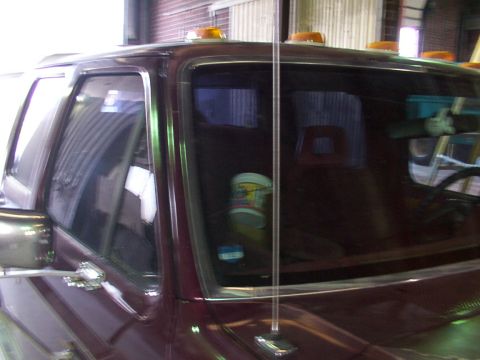 1988 Ford C-350 (Centurion Conversions) - Maroon truck cab with amber cab lights, side view. The body style suggests a 1980s model, not 1988.