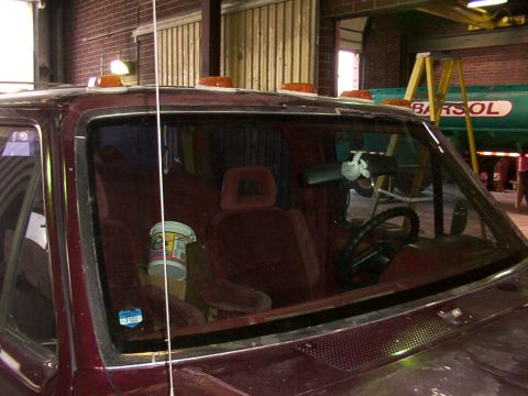 1988 Ford C-350 (Centurion Conversions) - The interior of a maroon truck is visible through the windshield, showing bucket seats and the dashboard. A sticker with the number 1122 is…