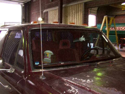 1988 Ford C-350 (Centurion Conversions) - The interior of a maroon truck is visible through the windshield, showing bucket seats and the dashboard.