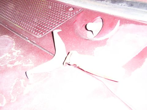 1988 Ford C-350 (Centurion Conversions) - Close-up of a vehicle's hood latch mechanism and a perforated metal grille.