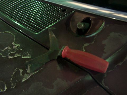 1988 Ford C-350 (Centurion Conversions) - A specialized tool designed for windshield wiper arm removal is shown on a weathered surface.