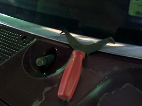 1988 Ford C-350 (Centurion Conversions) - A tool for removing windshield trim is placed on the dashboard of a vehicle.