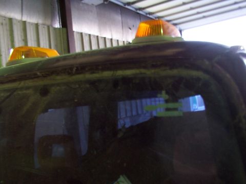 1988 Ford C-350 (Centurion Conversions) - The top of a dark vehicle is visible, two amber warning lights mounted on the roof.